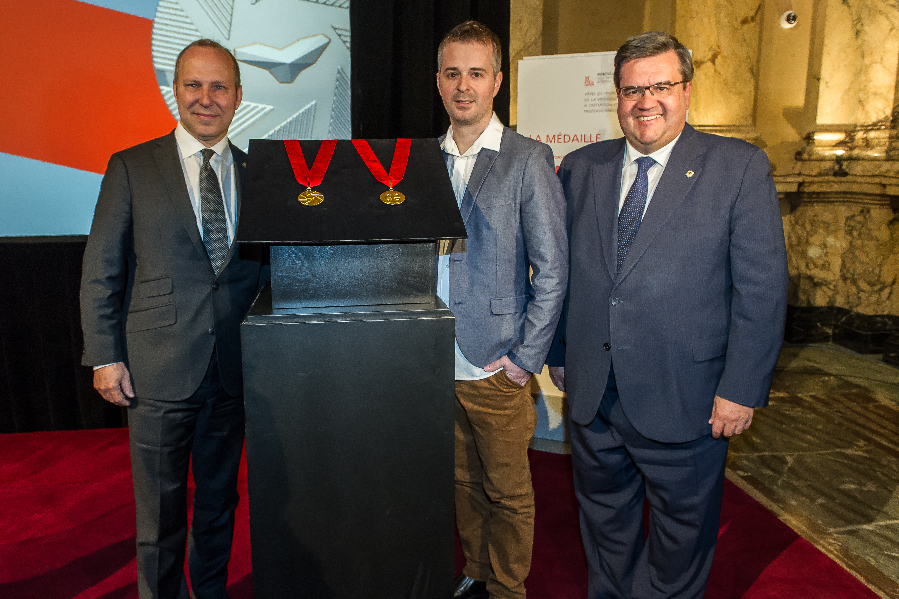 President of the Chamber of commerce Michel Leblanc, Industrial designer Jacques Desbiens and Mayor of Montreal Denis Coderre unveiling the Ordre de Montréal medal, at City Hall, on May 17, 2016